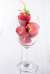 fresh strawberry in wine glass on wood background