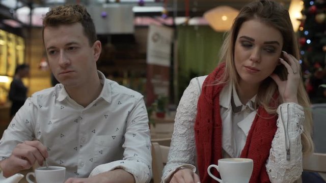Offended couple sitting in silence in the cafe, steadycam shot
