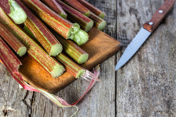 Fresh rhubarb stalks on wooden board for cutting
