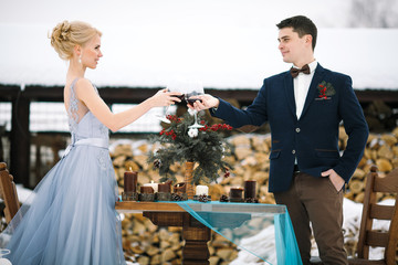 Winter wedding outdoor on table and firewood background.