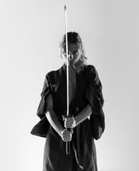 Blonde woman dressed like samurai with a katana © luismolinero