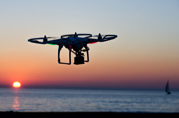 Fototapeta na wymiar Flying drone with camera on the sky at sunset