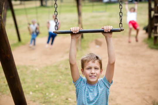 Boy hanging on a playing equipment in park