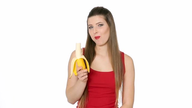 beautiful girl eats banana on white background