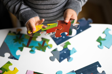 Childs hands connecting jigsaw puzzle 