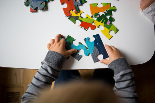Childs hands connecting jigsaw puzzle 