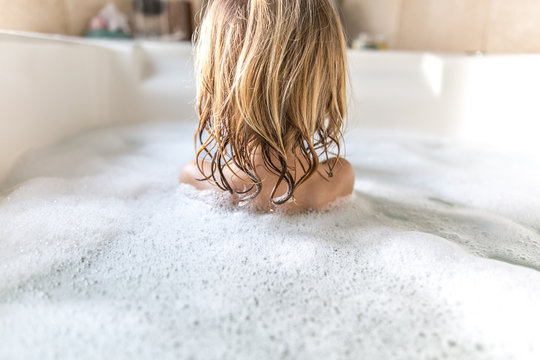 Rear view of girl having bubble bath