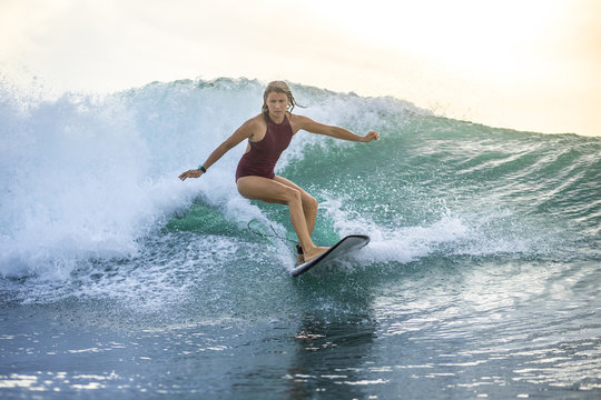 Indonesia, Bali, woman surfing on a wave