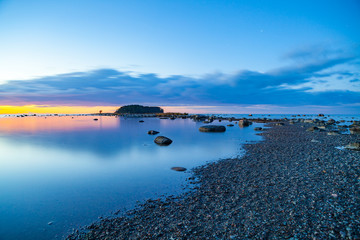 Seascape sunset with rocks and pebble coast of Baltic sea