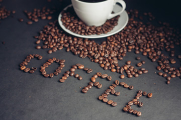 an inscription from coffee beans and a drink in a cup