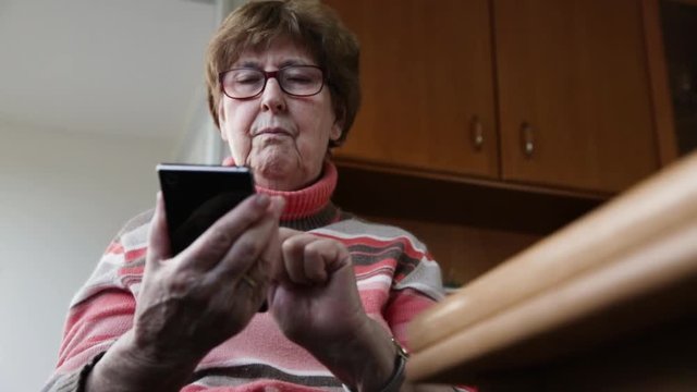 Seniorin schreibt eine Nachricht auf ihrem Smartphone