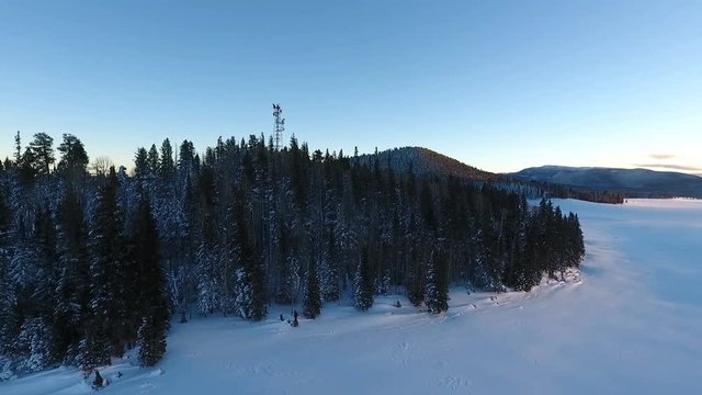 Aerial view of a communications tower in a snow covered forest