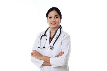 Smiling young doctor woman against white background