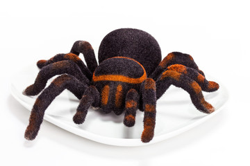 Black and orange spider stuffed animal on plate