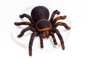 Black and orange spider stuffed animal on white plate