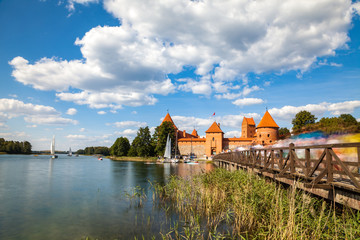 Tourists visit Trakai castle in sunny siummer day, nice time to have boat trip. Long exposure, motion blur