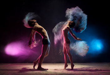 Young couple poses in color dust cloud studio shot