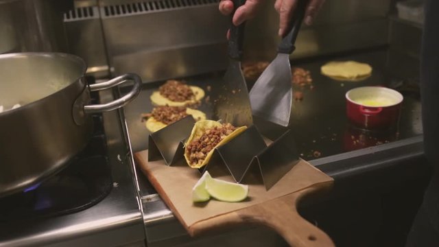 Chef cooking delicious mexican tacos in a restaurant.