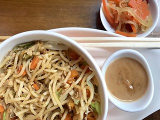 Close up of fried noodles with peanut butter sauce and veggies