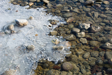 Steine im Fluss mit vereistem Wasser