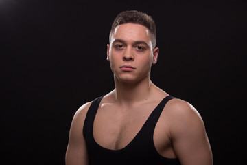 man tired muscular, good looking, sleeveless t-shirt posing