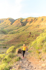 Young woman running on mountain trail