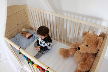 Ein Kleinkind in seinem Kinderbett