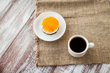 orange pastry in a dish is isolated on a wooden background