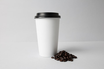 Fototapeta na wymiar White paper cup with coffee beans