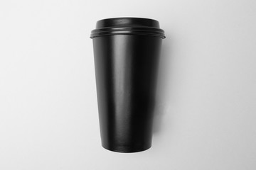 Blank black paper cup on the grey background