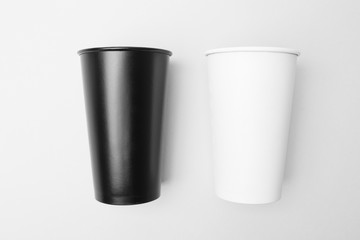 Blank white and black paper cup on the grey background