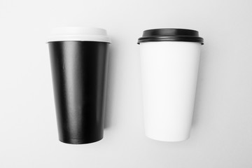 Blank white and black paper cup on the grey background