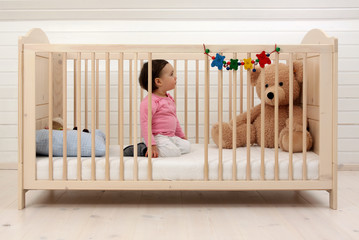 Ein Kleinkind in seinem Kinderbett