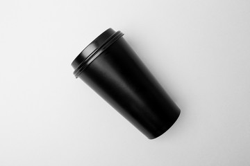 Blank black paper cup on the gray background