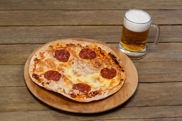 Delicious pizza served on pizza tray with a glass of beer