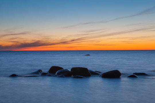 Minimalistic piture of sunrise on Baltic sea. Rocky coast of Estonian island