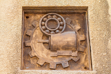 Gears and motor emblem at abandoned USSR plant