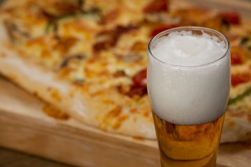 Delicious pizza served on pizza tray with a glass of beer