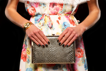young girl in a colorful dress is holding his elegant bag
