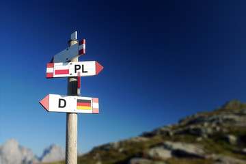 Polish and German flags on mountain road sign. Policy and relationships concept
