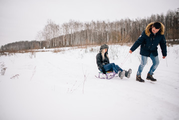Fototapeta na wymiar beautiful young couple riding the mountain on a sled. winter love story