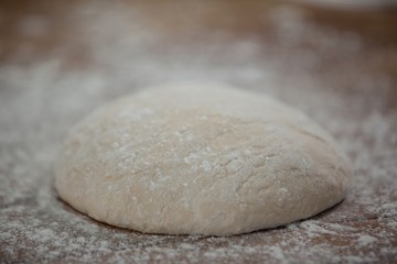 Fototapeta na wymiar Pizza dough and flour on rolling board