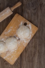 Rolling pin with pizza dough and flour on chopping board