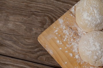 Pizza dough and flour on chopping board