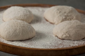 Fototapeta na wymiar Pizza dough and flour on rolling board