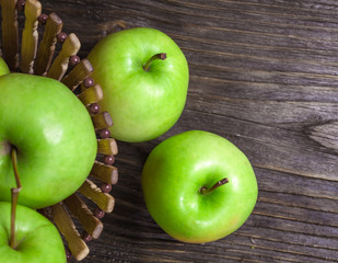 ripe green apples and apple slices on wooden gray background