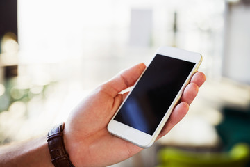 Close-up of smartphone with empty screen held by men