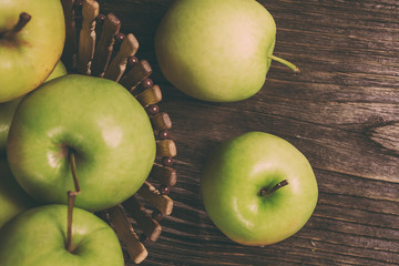 ripe green apples and apple slices on wooden gray background