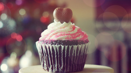 Chocolate heart on top of cupcake for valentine on colorful boke