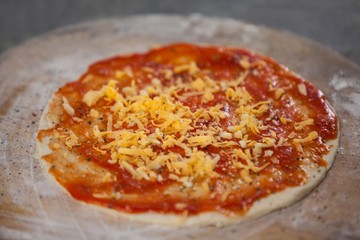 Pizza dough with tomato sauce with grated cheese